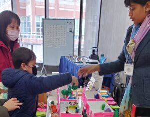 child placing blocks into boxes